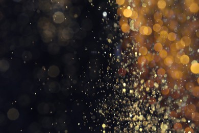 Photo of Blurred view of golden lights on black background, space for text. Bokeh effect