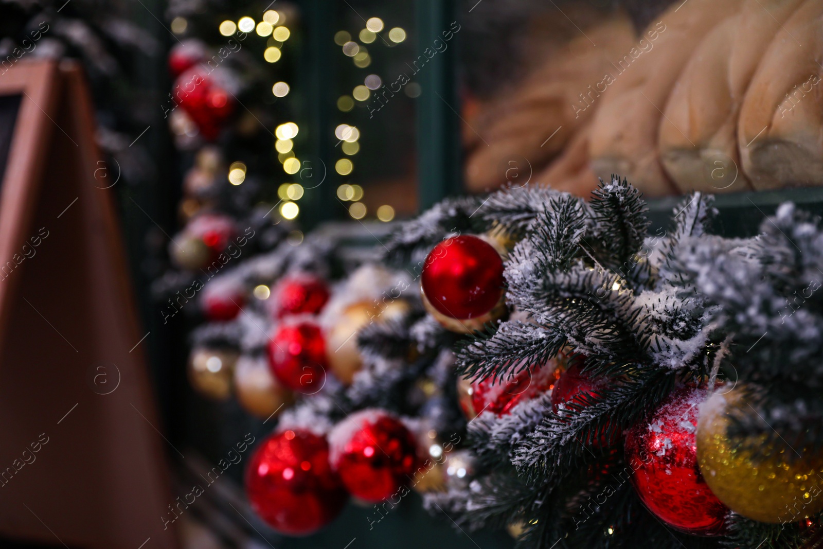 Photo of Beautiful decorative garland near window outdoors. Christmas celebration