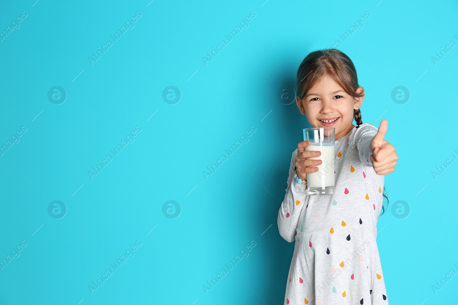 Photo of Cute little girl with glass of milk on color background