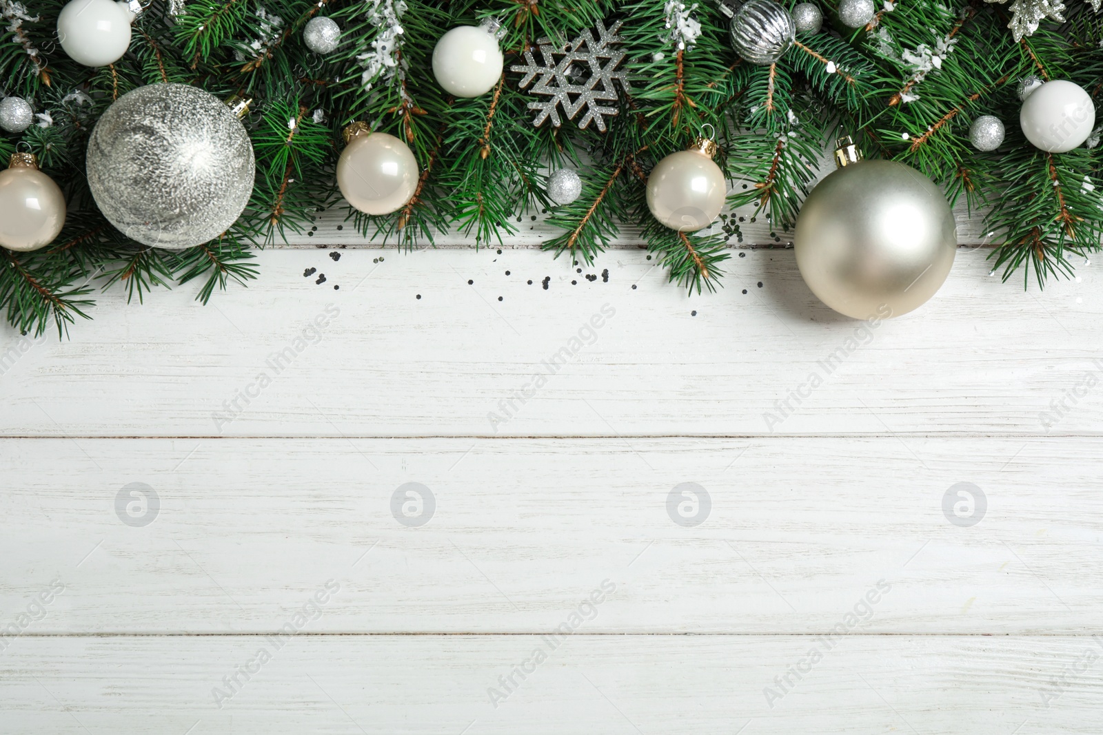 Photo of Fir tree branches with Christmas decoration on white wooden background, flat lay. Space for text