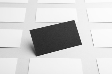 Photo of Blank black and white business cards on light background. Mockup for design