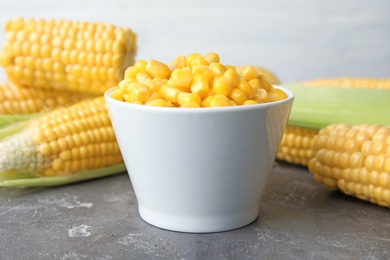 Photo of Bowl with corn kernels on grey table