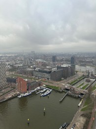 Photo of Picturesque view of city with modern buildings and harbor on cloudy day