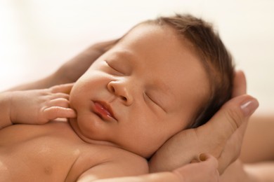 Photo of Woman holding her sleeping newborn baby, closeup