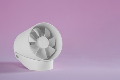 Photo of Modern electric fan on pink background. Space for text