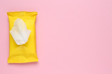 Photo of Wet wipes flow pack on pink background, top view. Space for text