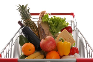 Photo of Shopping cart with groceries on white background, closeup