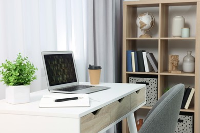 Photo of Workplace with modern laptop on desk at home