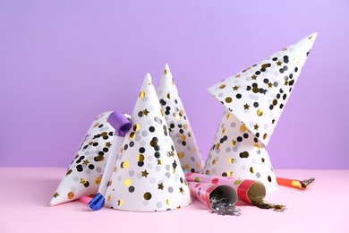 Photo of Party hats, confetti and blowers on color background
