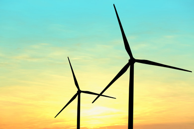 Image of Silhouettes of wind turbines at sunset. Alternative energy source