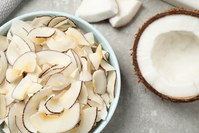 Photo of Tasty coconut chips on grey table, flat lay