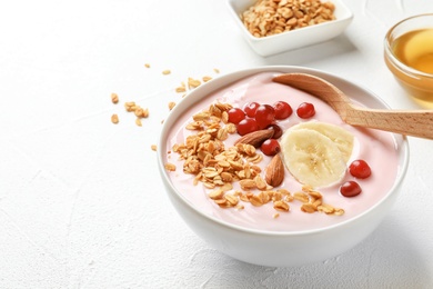 Photo of Bowl with delicious yogurt and granola on table