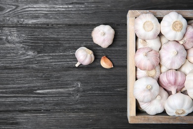 Photo of Crate with fresh garlic bulbs on wooden background, top view