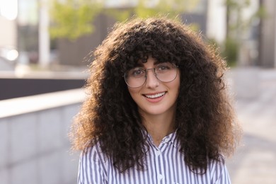 Photo of Portrait of beautiful woman in glasses outdoors. Attractive lady smiling and looking into camera