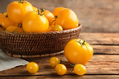 Photo of Delicious ripe yellow tomatoes on wooden table