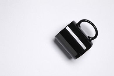 Photo of Black ceramic mug on light grey background, top view. Space for text