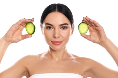 Photo of Young woman with silky skin after face mask holding cucumber on white background