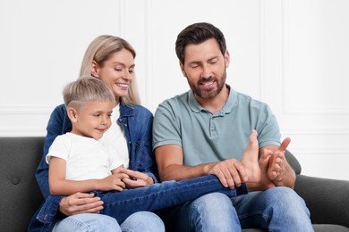 Photo of Happy family having fun together on sofa at home