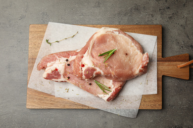 Photo of Fresh raw beef cut with spices on grey table, top view