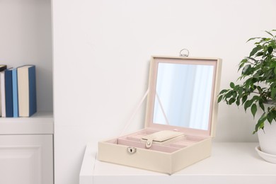 Photo of Empty jewelry box with mirror and houseplant on white table