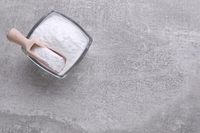 Photo of Bowl of sweet fructose powder on light grey table, top view. Space for text