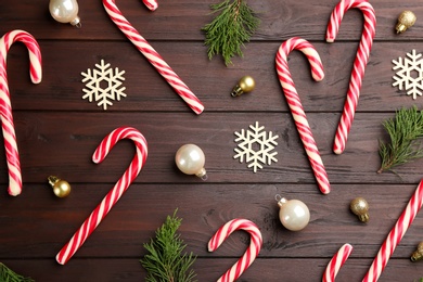 Photo of Flat lay composition with candy canes and Christmas decor on wooden table