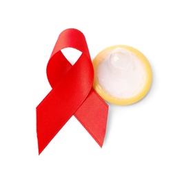 Photo of Red ribbon and condom isolated on white. AIDS disease awareness