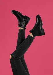 Photo of Woman wearing stylish boots on pink background, closeup