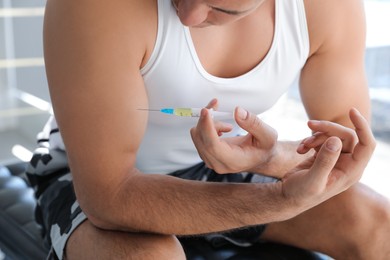 Photo of Sportsman injecting himself indoors, closeup. Doping concept