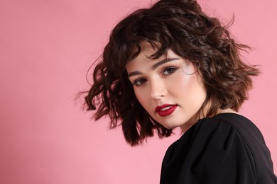 Photo of Portrait of beautiful young woman with wavy hairstyle on pink background. Space for text