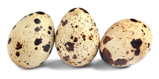 Photo of Three beautiful quail eggs on white background