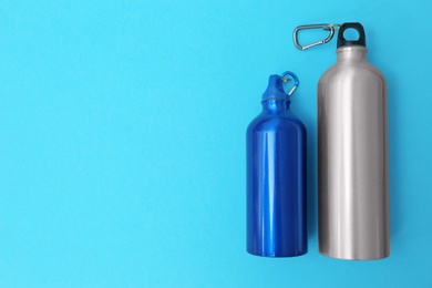 Photo of Sport bottles with space for text on color background, top view