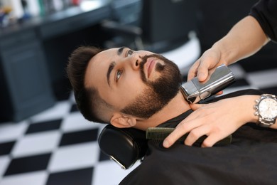 Photo of Professional hairdresser working with client in barbershop