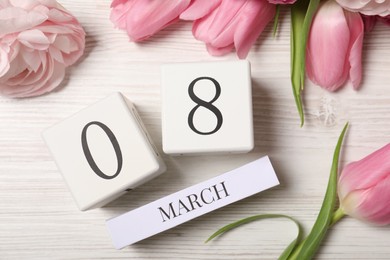 Photo of International Women's day - 8th of March. Block calendar and beautiful flowers on white wooden table, flat lay