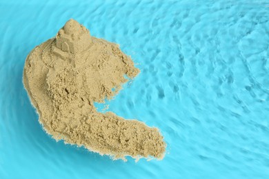 Photo of Pile of sand with sultan's palace on rippled water, space for text. Beautiful castle