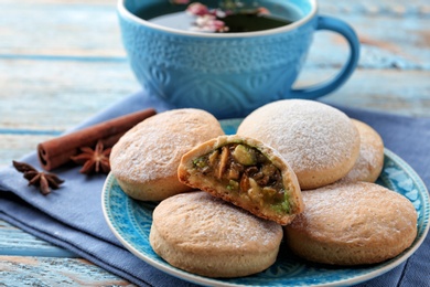 Photo of Traditional cookies for Islamic holidays and tea on wooden table. Eid Mubarak