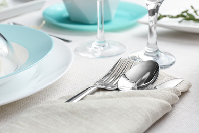 Photo of Elegant cutlery with green leaves on table, closeup. Festive setting