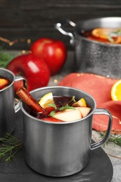 Photo of Tasty mulled wine with spices on grey table