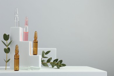 Photo of Stylish presentation of different skincare ampoules on white background. Space for text