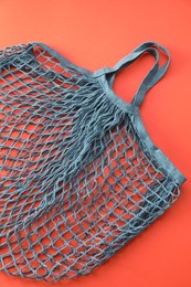 Photo of Blue string bag on red background, top view