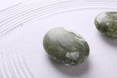 Photo of Stones on sand with pattern. Zen concept