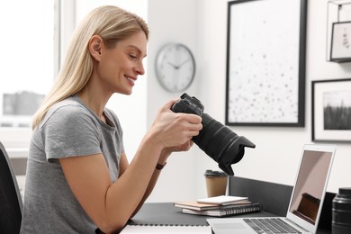 Photo of Professional photographer with digital camera at table in office