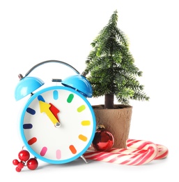 Photo of Alarm clock with small fir, festive decor and candy canes on white background. New Year countdown