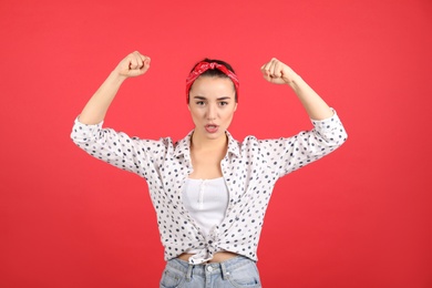 Photo of Strong woman as symbol of girl power on red background. 8 March concept