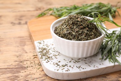 Photo of Dry and fresh tarragon on wooden table, space for text
