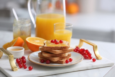 Toasted bread with jam and fresh cranberries on tray in kitchen