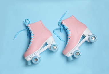 Photo of Pair of stylish quad roller skates on color background, top view