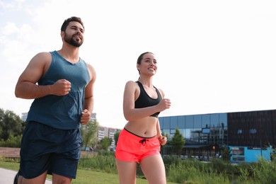 Photo of Healthy lifestyle. Happy couple running outdoors, space for text