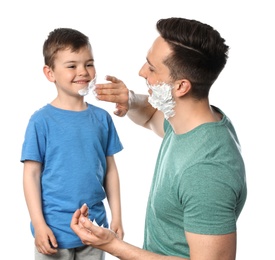 Photo of Dad applying shaving foam onto son's face against white background