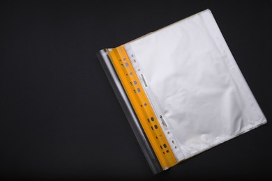 Photo of File folder with punched pockets on black background, flat lay. Space for text